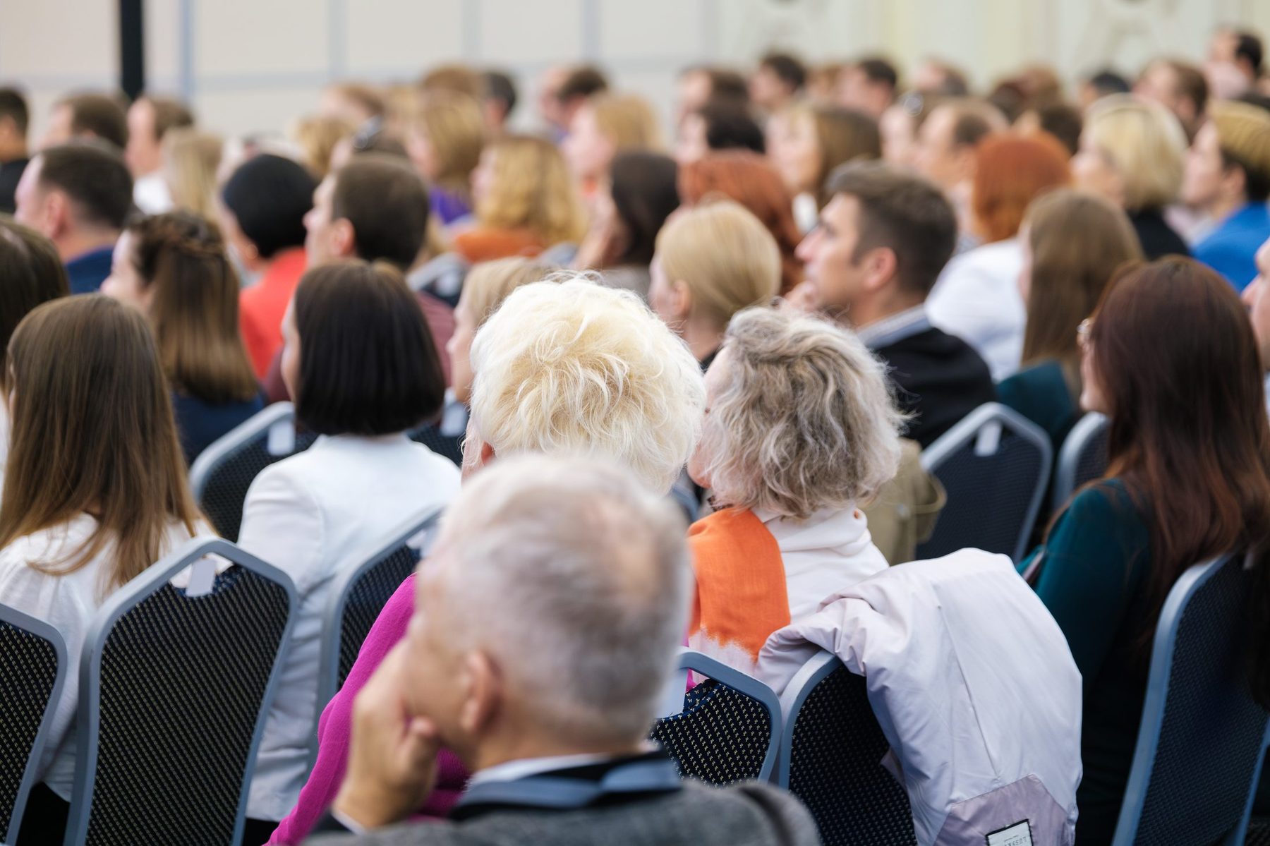 A large audience of adults seated in rows at a conference